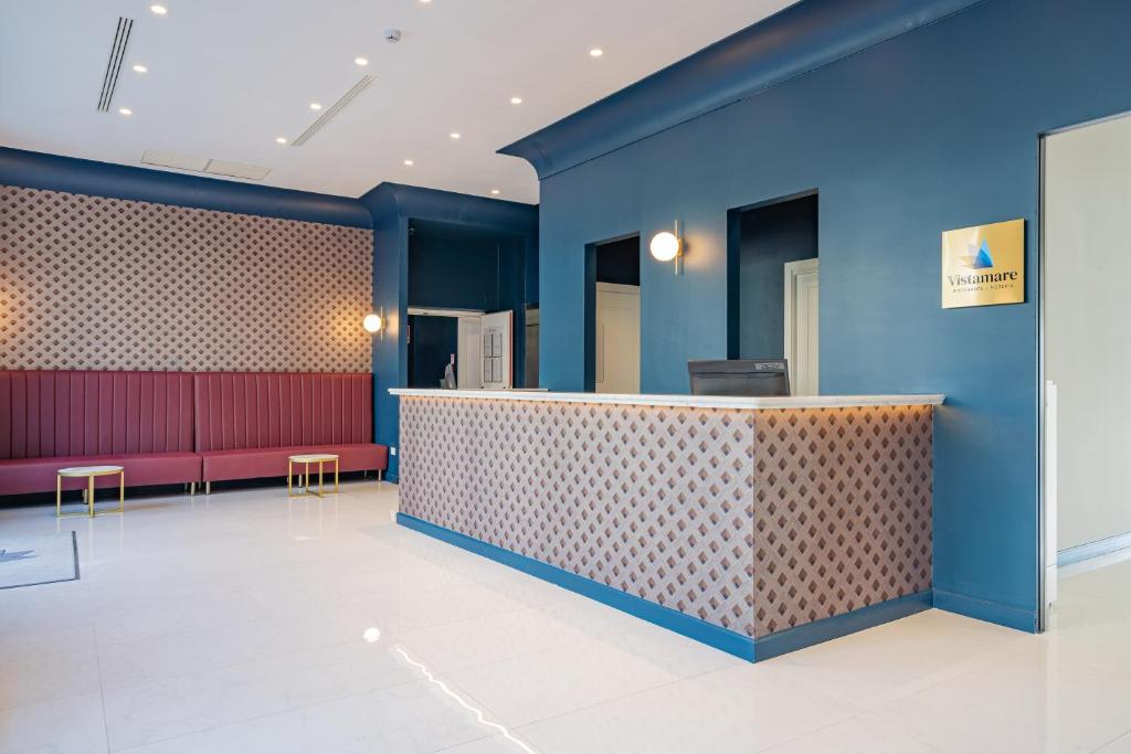 un hall avec des murs bleus et un bar avec des bancs rouges dans l'établissement Hotel Mary, à Vico Equense 157 autres photos