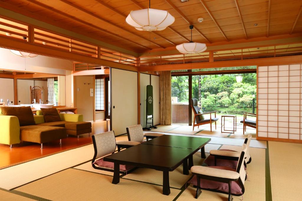 un salon avec une table et des chaises dans l'établissement Oku Yugawara SANSUIROU, à Yugawara