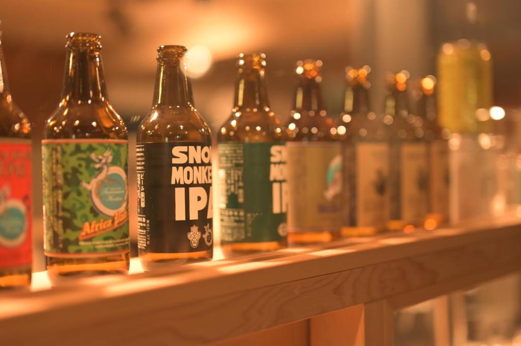 une rangée de bouteilles de bière assise sur une étagère dans l'établissement Shibu Onsen KADOYA, à Yamanouchi