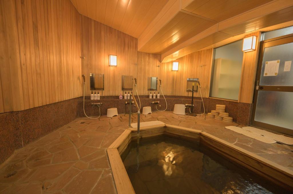 - une grande salle de bains avec une grande baignoire au milieu dans l'établissement Shibu Onsen KADOYA, à Yamanouchi