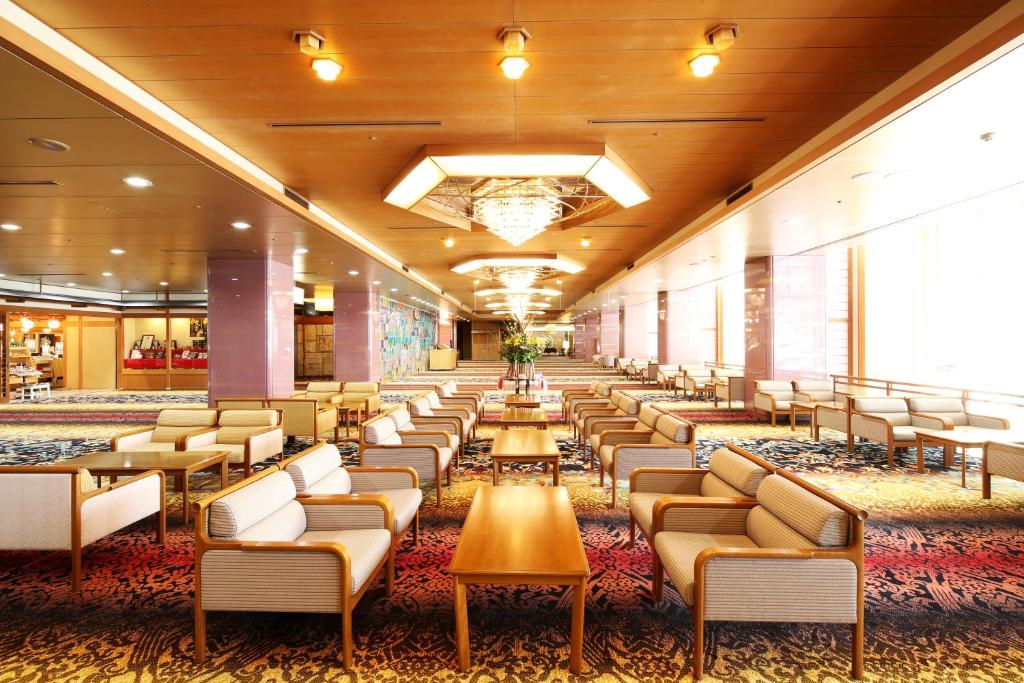 une salle d'attente dans un hôtel avec des chaises et des tables dans l'établissement Hotel Sakurai, à Kusatsu