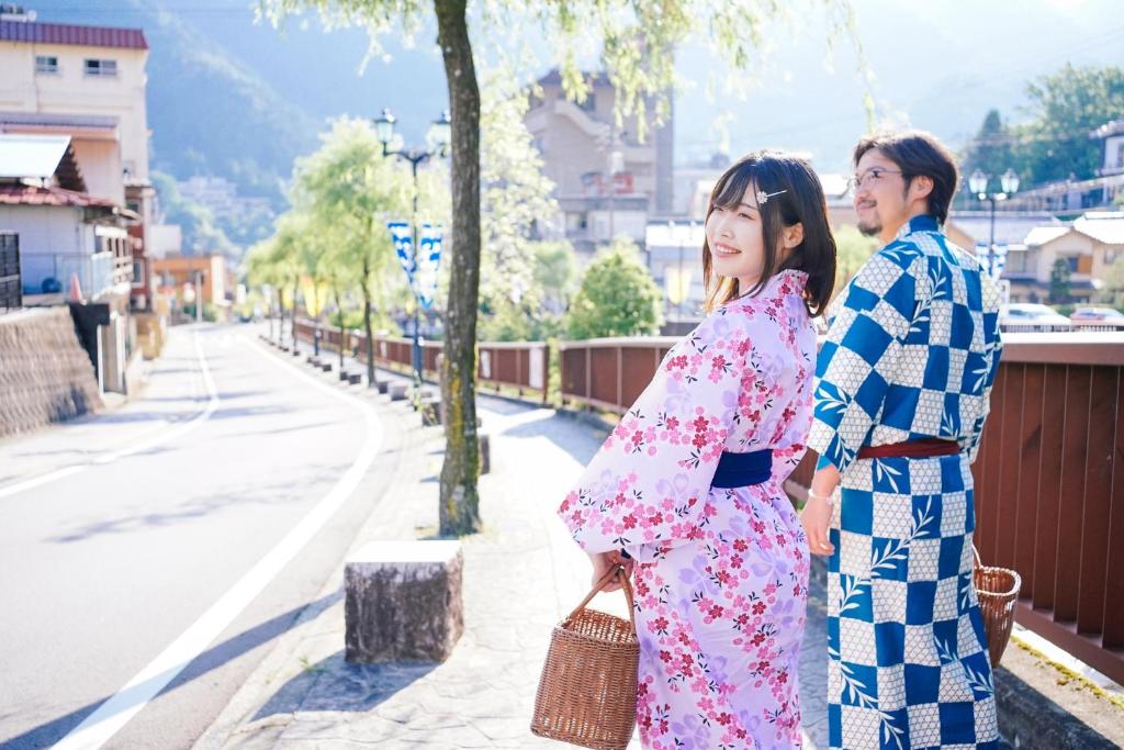 un couple en kimono marchant dans la rue dans l'établissement 寅家 Japanese modern hotel, à Gero