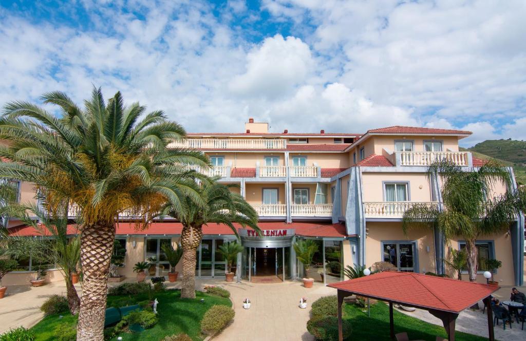un grand bâtiment avec des palmiers devant dans l'établissement Park Hotel Tyrrenian, à Amantea