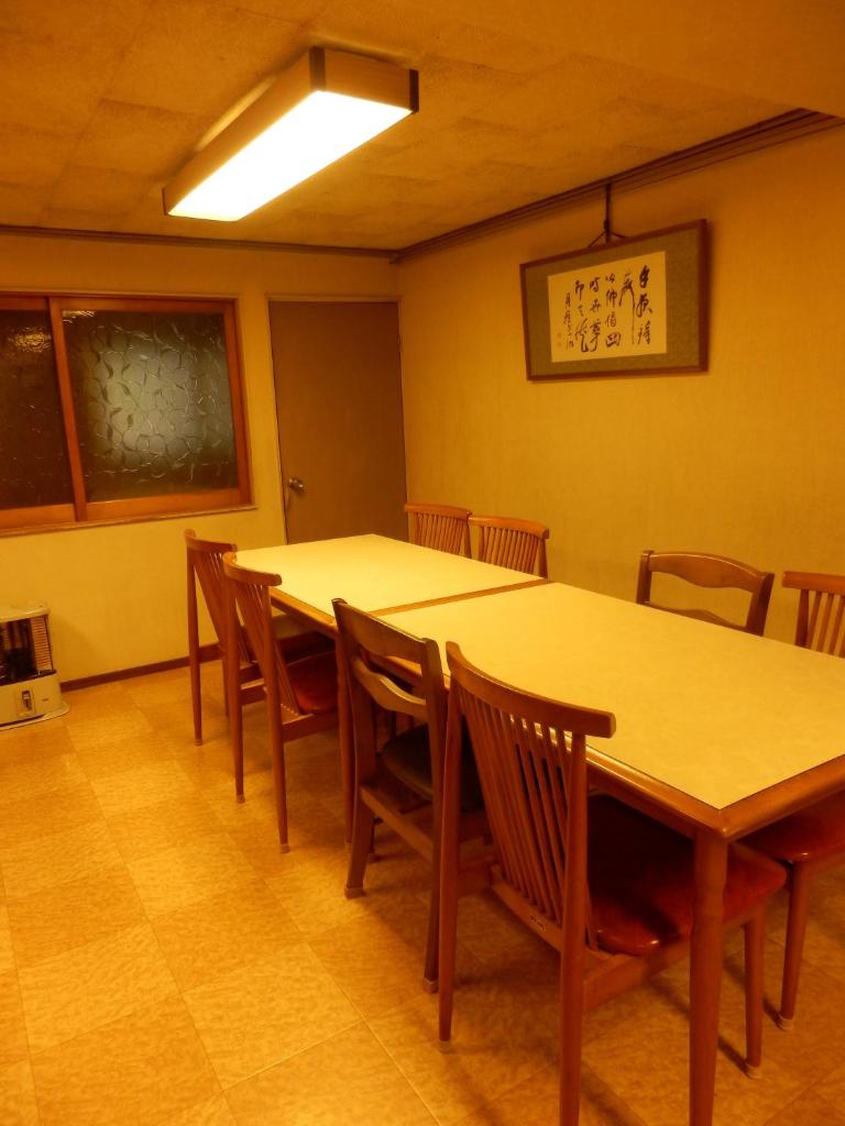 - une salle à manger avec deux tables et des chaises en bois dans l'établissement Murataya, à Kanazawa