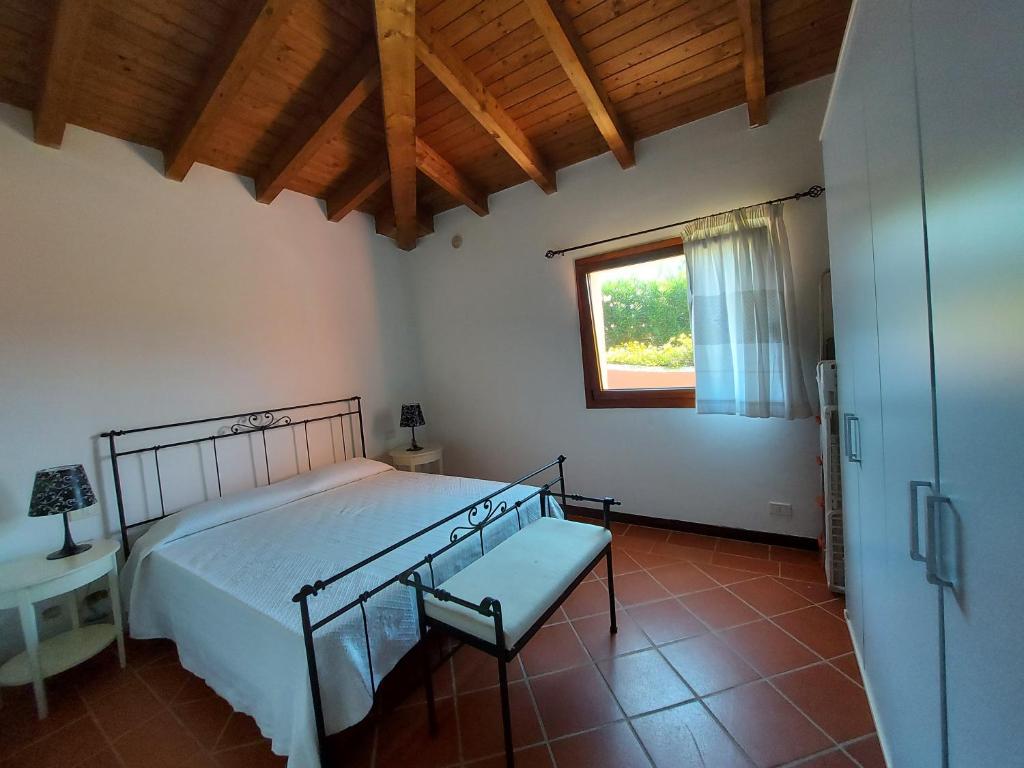 une chambre avec un lit et une fenêtre dans l'établissement Villa Venere, à Stintino