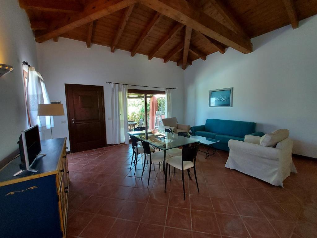 un salon avec un canapé bleu et une table dans l'établissement Villa Venere, à Stintino