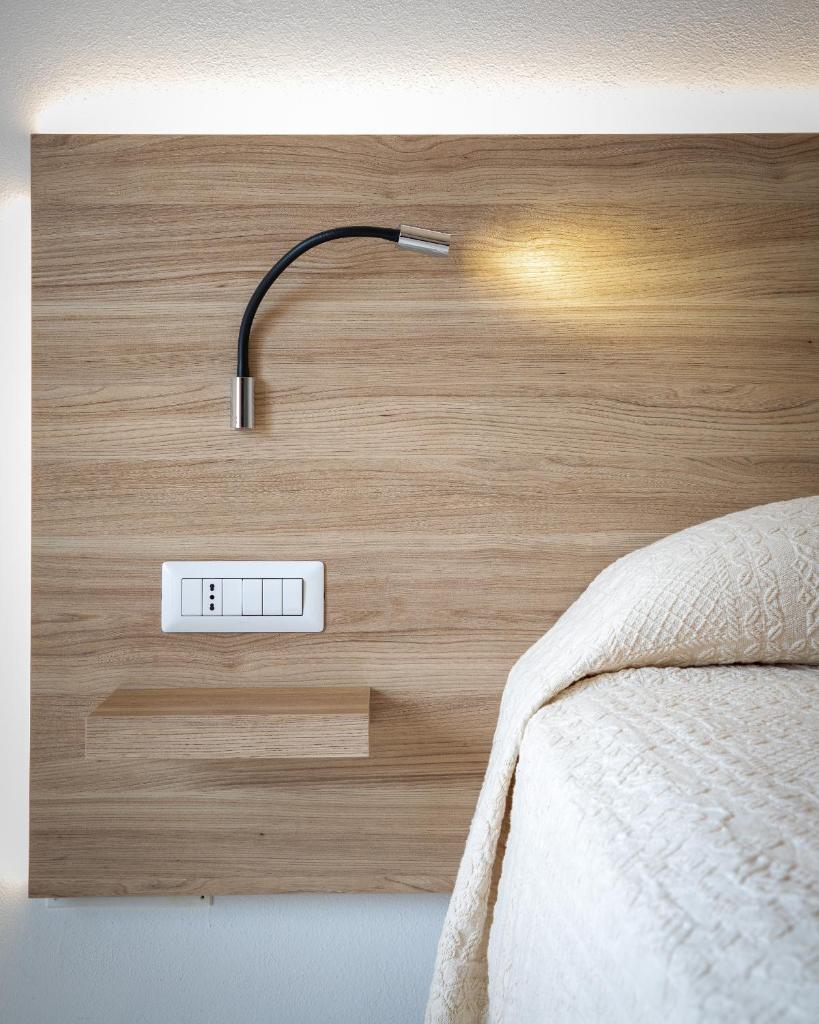un lit avec une lampe au-dessus d'une tête de lit en bois dans l'établissement Lu' Hotel Porto Pino, à SantʼAnna Arresi 75 autres photos