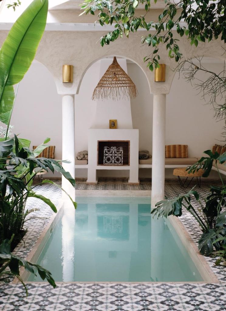 - une piscine dans une maison dotée d'une cheminée dans l'établissement Riad L'Atelier, à Marrakech