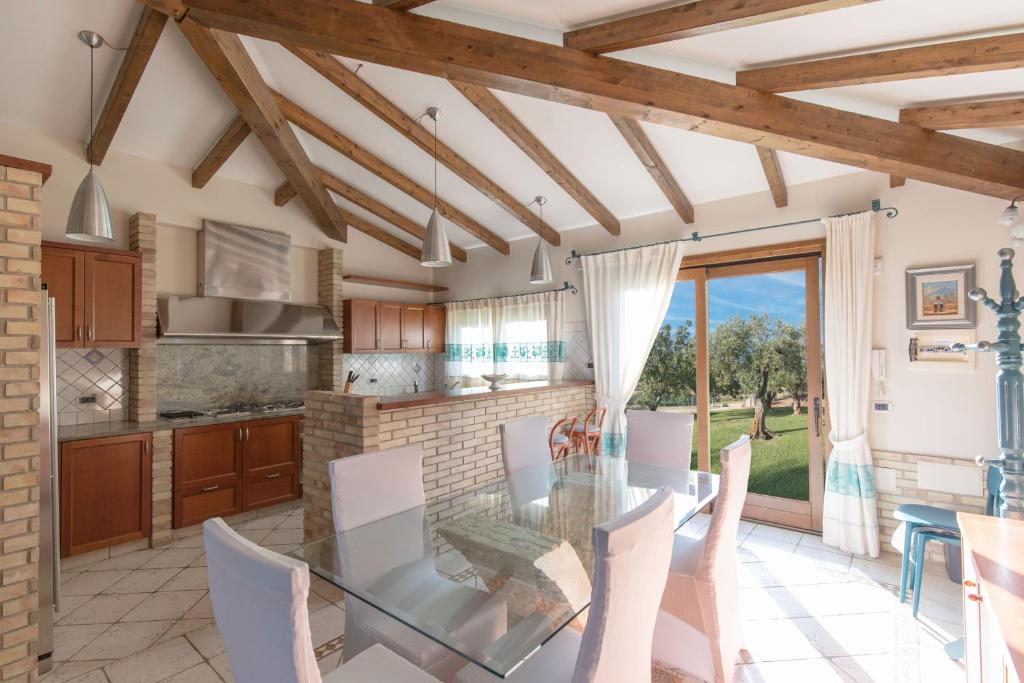 une cuisine et une salle à manger avec une table et des chaises en verre dans l'établissement Villa Palmetto, à Forte Village