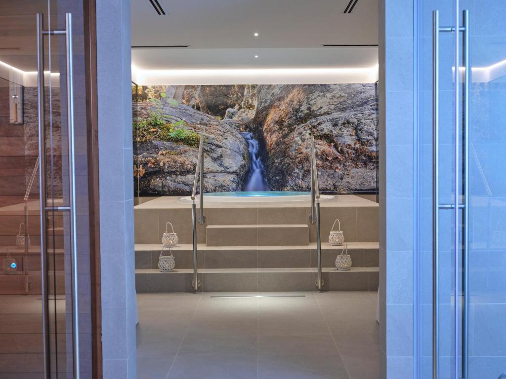 une salle de bain avec une peinture représentant une cascade dans l'établissement Hotel L'Esagono, à San Teodoro