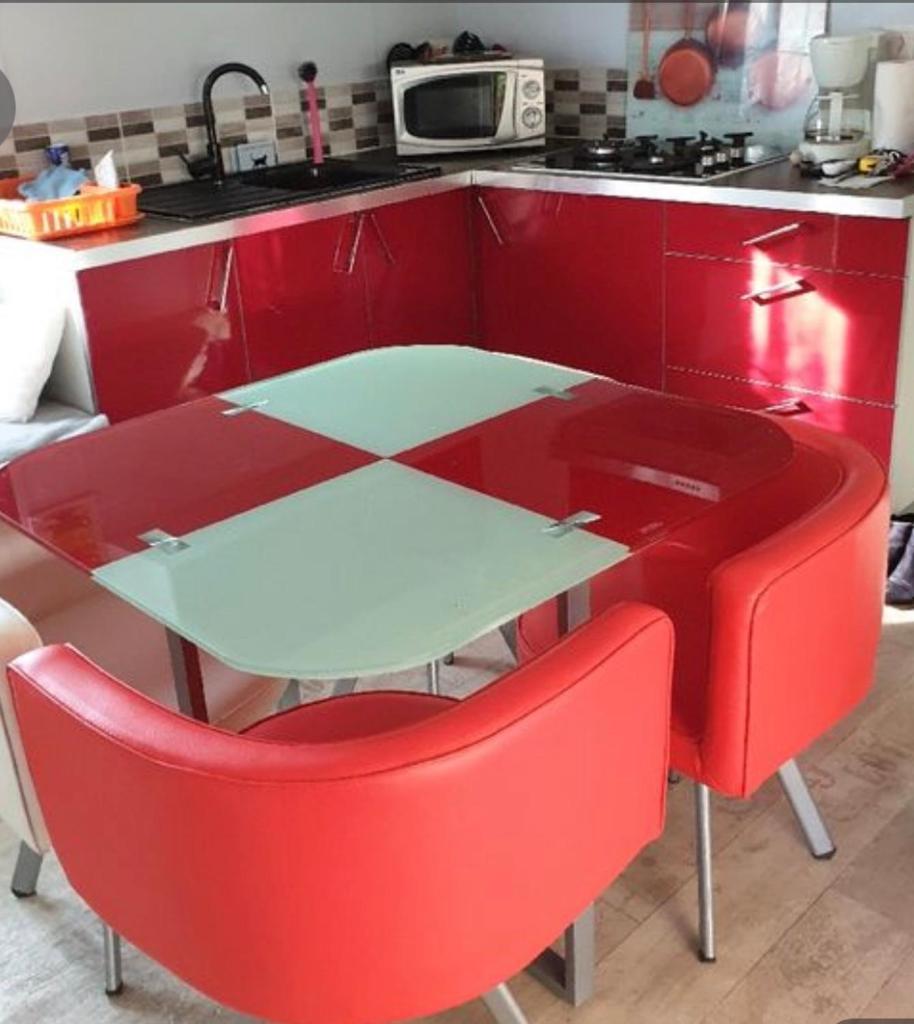 une cuisine rouge avec une table et deux chaises rouges dans l'établissement Mobilehome 3 chambres curistes camping piscine, à Saint-Paul-lès-Dax
