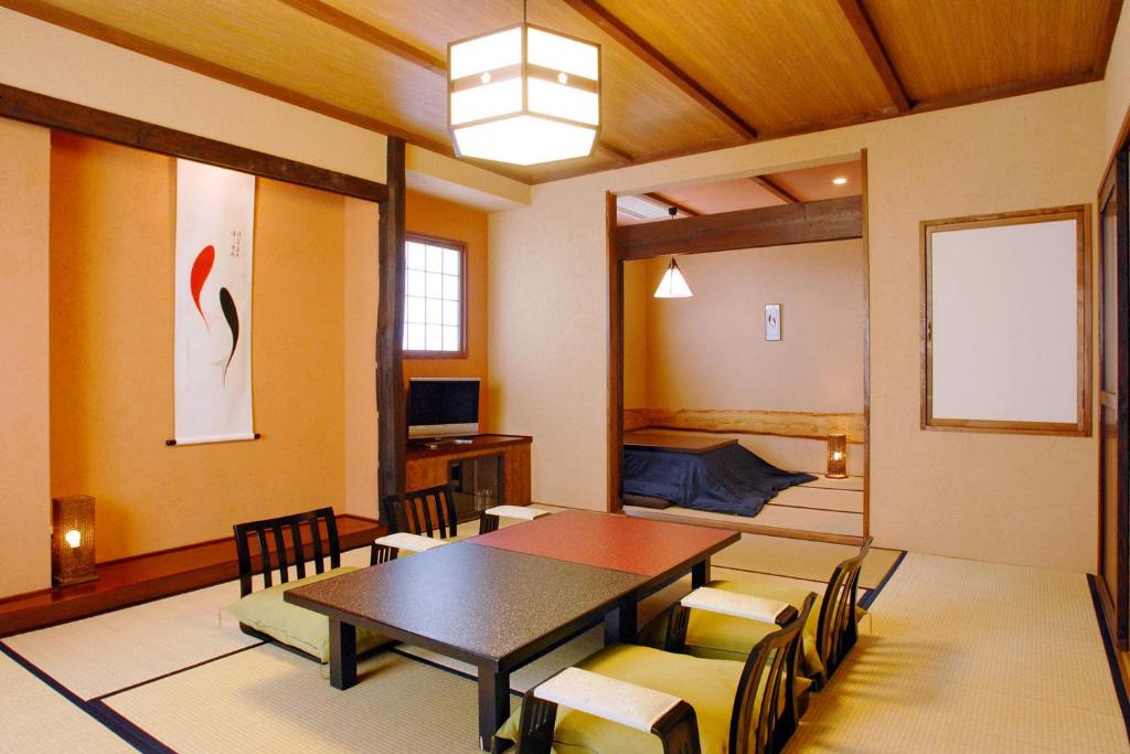 - une salle à manger avec une table, des chaises et un lit dans l'établissement Sawaemon, à Chino