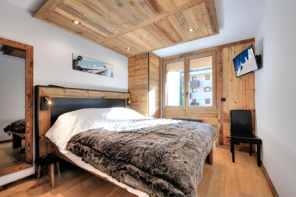 une chambre avec un lit et une chaise dedans dans l'établissement Appartement familial au pied de la télécabine 4*, à Saint-Gervais-les-Bains