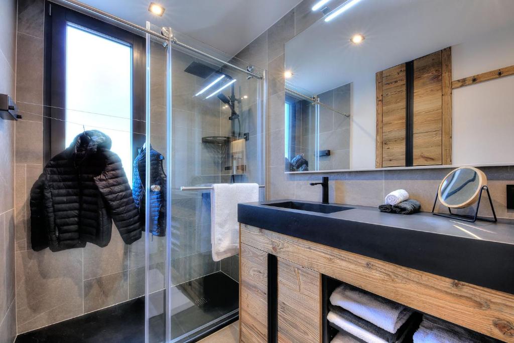 une salle de bain avec un lavabo et une douche en verre dans l'établissement Appartement familial au pied de la télécabine 4*, à Saint-Gervais-les-Bains 9 autres photos