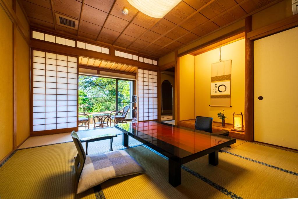 une chambre japonaise avec une table et des chaises dans l'établissement Beppu Showaen, à Beppu