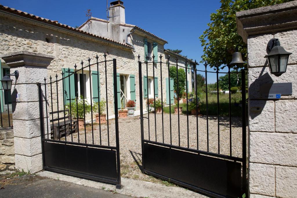 un portail en fer devant un bâtiment dans l'établissement La Dorépontaise YOURTE MONGOLE, à Pondaurat