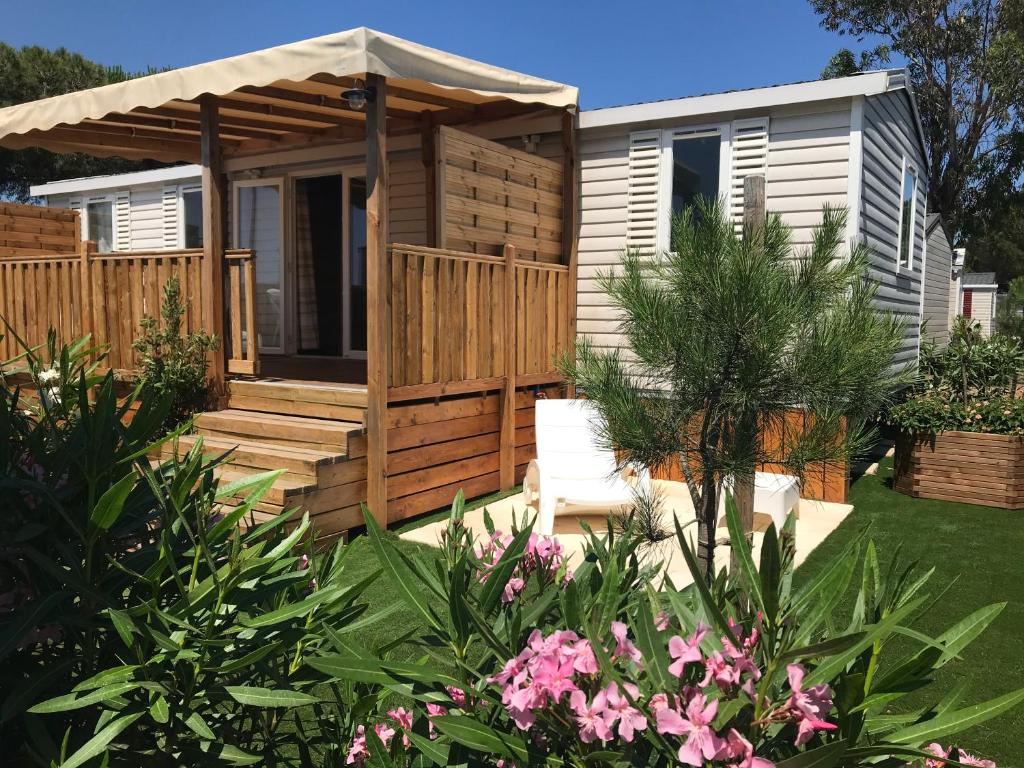 une petite maison avec une terrasse et un kiosque dans l'établissement Mobil Home camping Mar Estang bord de plage, à Canet
