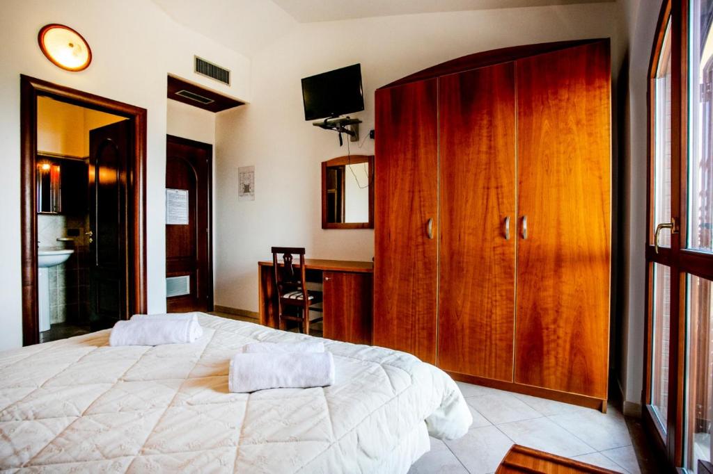 - une chambre avec un grand lit et une armoire en bois dans l'établissement Hotel Gran Duca, à Briatico