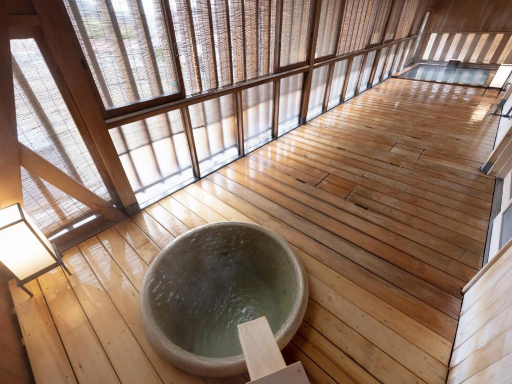 une grande baignoire assise sur du parquet dans l'établissement Shojuen, à Minakami