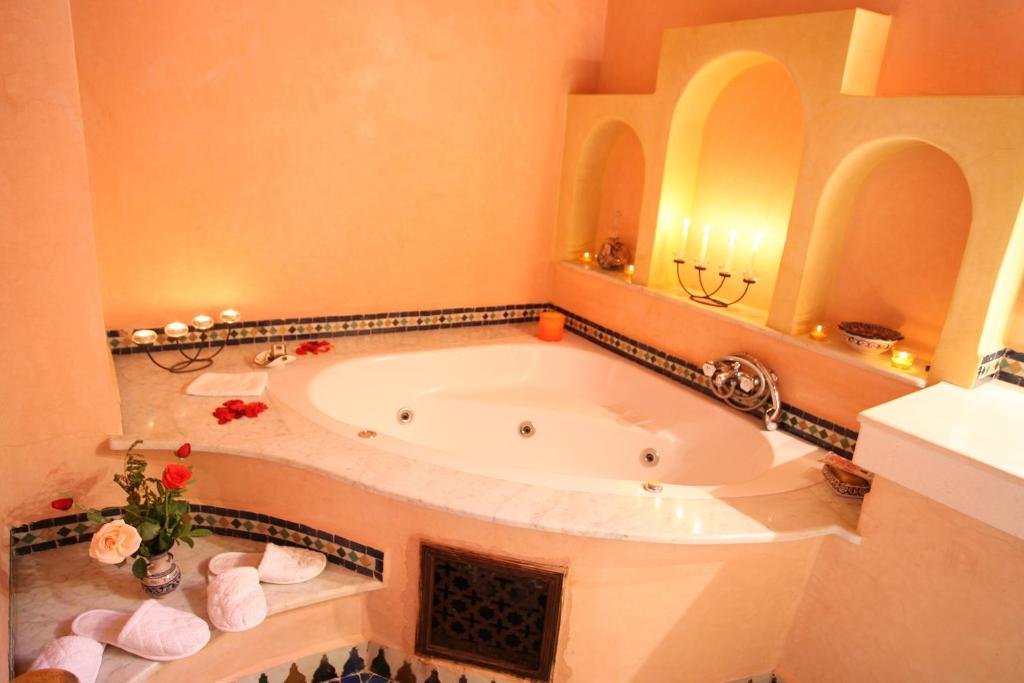 Cette chambre comprend une salle de bains pourvue d'une grande baignoire. dans l'établissement Riad - Dar Al Andalous, à Fès