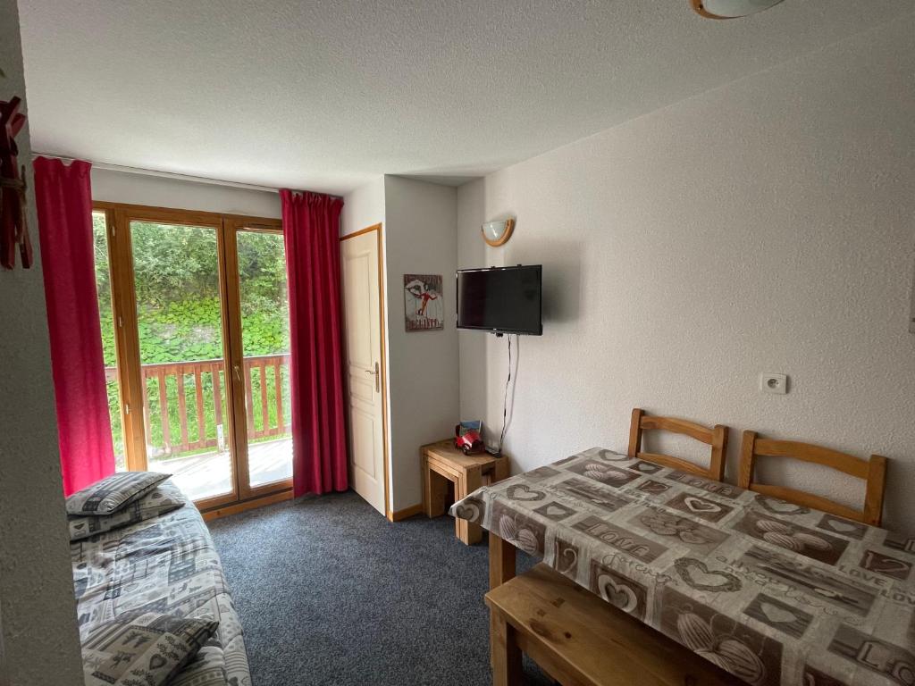 une chambre avec un lit, une télévision et une fenêtre dans l'établissement Le ValmySki, à Valmeinier