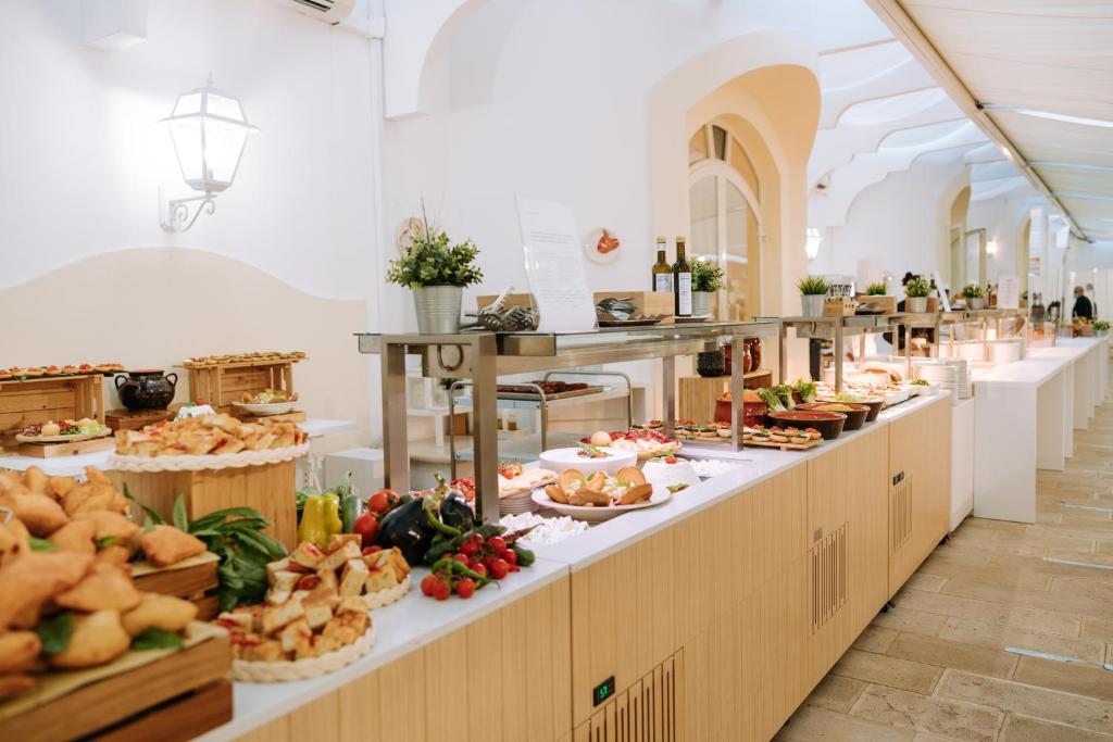 une ligne de buffet avec beaucoup de nourriture en exposition dans l'établissement Nicolaus Prime Il Gabbiano Hotel, à Pulsano