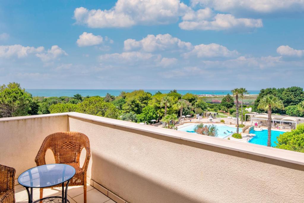 d'un balcon avec des chaises et une vue sur la piscine. dans l'établissement Nicolaus Club La Giurlita, à Ugento