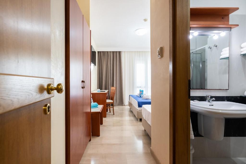 une salle de bain avec un lit, un lavabo et un miroir dans l'établissement Nicolaus Club La Giurlita, à Ugento