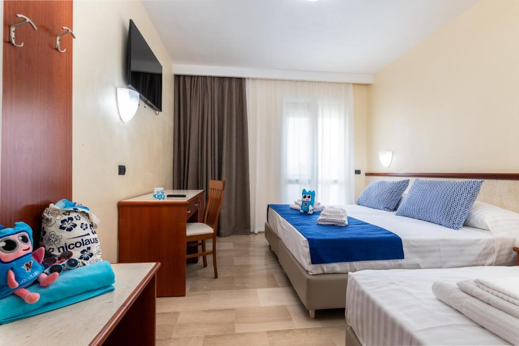 une chambre d'hôtel avec deux lits et un bureau dans l'établissement Nicolaus Club La Giurlita, à Ugento