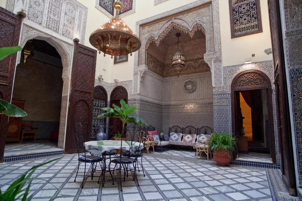 une cour d'une mosquée avec une table et des chaises dans l'établissement Riad Fes Palacete, à Fès