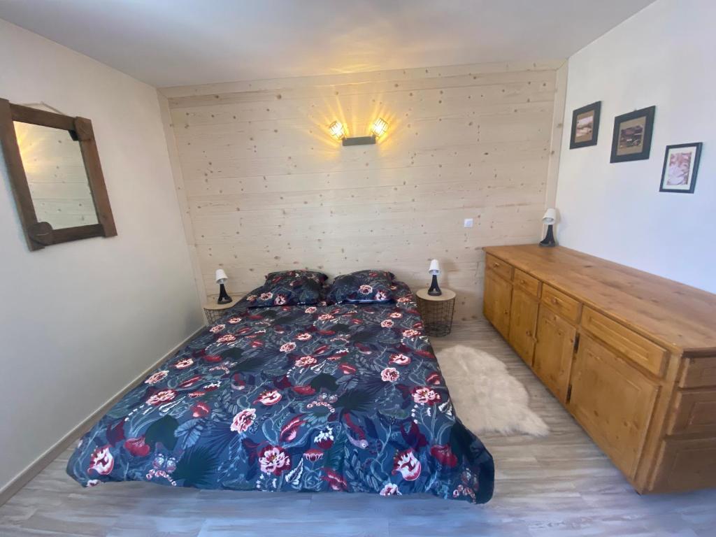 - une chambre avec un grand lit et une commode en bois dans l'établissement Praloup 1600 t3 sur piste 4p, à Uvernet