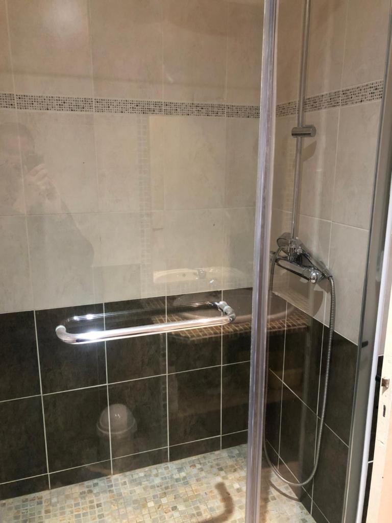 une douche avec une porte vitrée dans une salle de bain dans l'établissement Praloup 1600 t3 sur piste 4p, à Uvernet