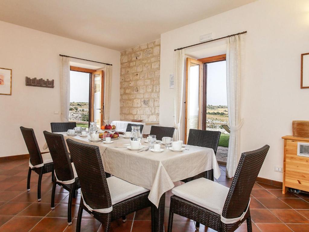 une salle à manger avec une table, des chaises et des fenêtres dans l'établissement Villa al Castello by Interhome, à Pietre Nere San Zagaria 48 autres photos