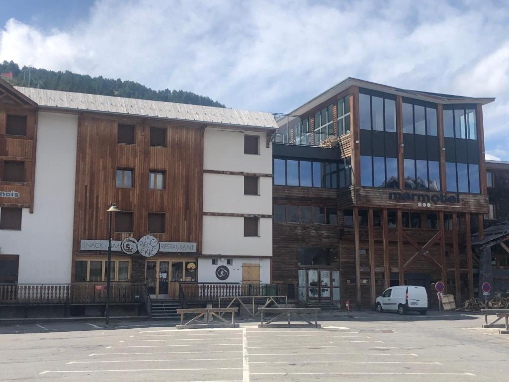 un groupe de bâtiments dans un parking dans l'établissement Praloup 1600 t3 sur piste 4p, à Uvernet