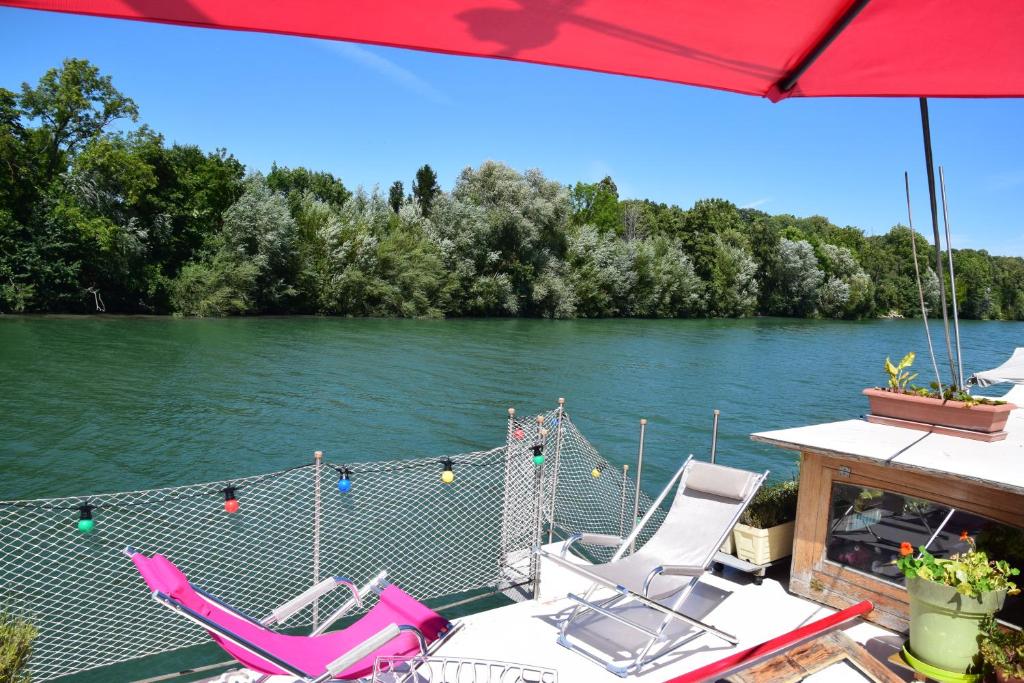 un groupe de chaises assises sur une terrasse à côté d'une rivière dans l'établissement Bateau, Péniche Marboré - Disney, à Lagny-sur-Marne