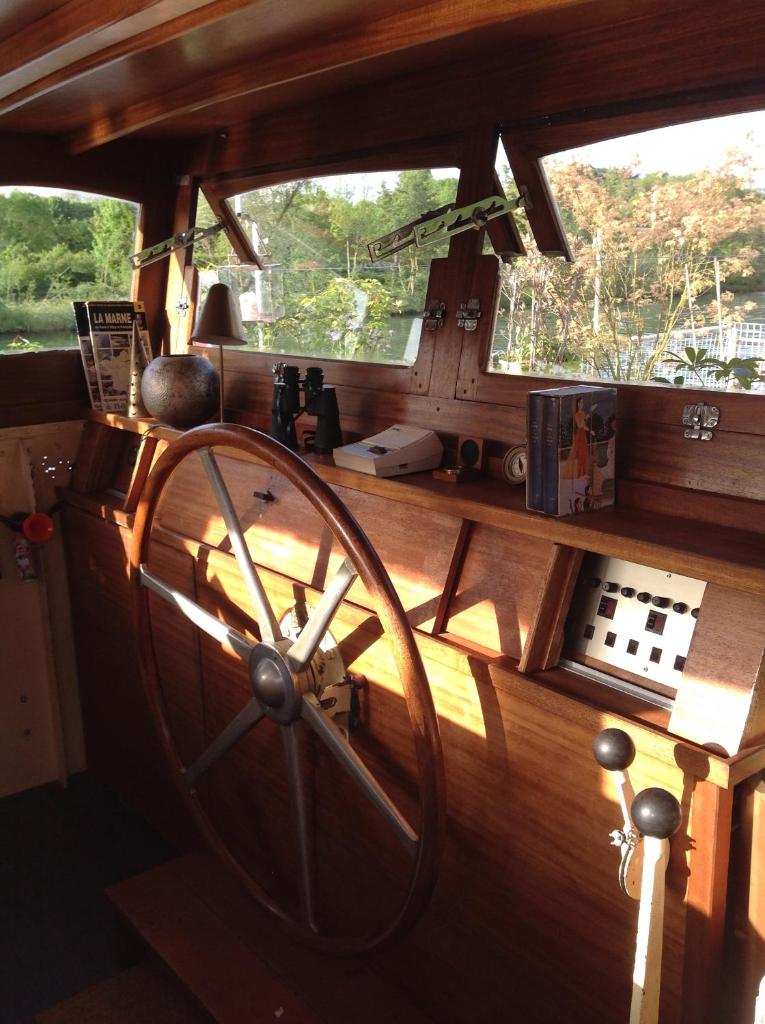 une grande roue en bois dans une chambre avec deux fenêtres dans l'établissement Bateau, Péniche Marboré - Disney, à Lagny-sur-Marne