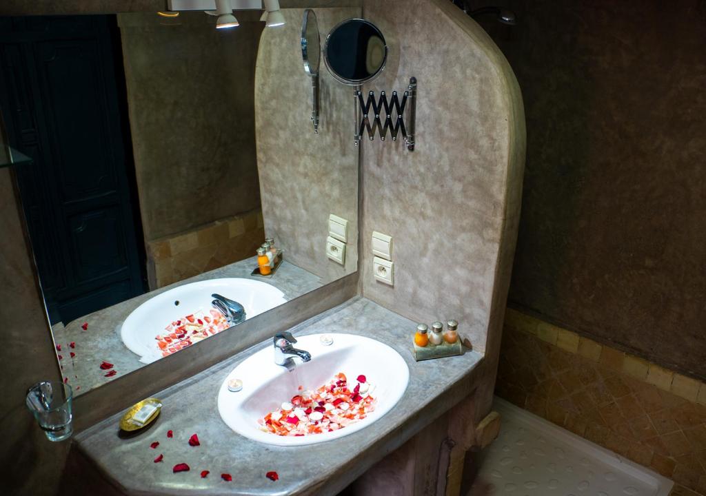 une salle de bain avec deux lavabos et un miroir dans l'établissement Riad Romance, à Marrakech