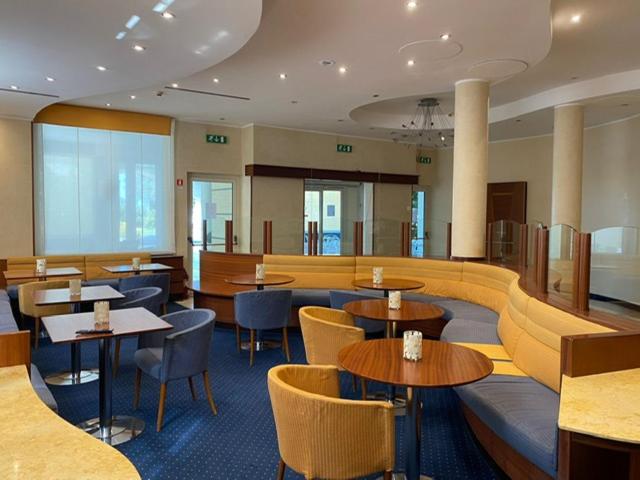 un restaurant avec des tables et des chaises dans une salle dans l'établissement Nicotel Barletta, à Barletta