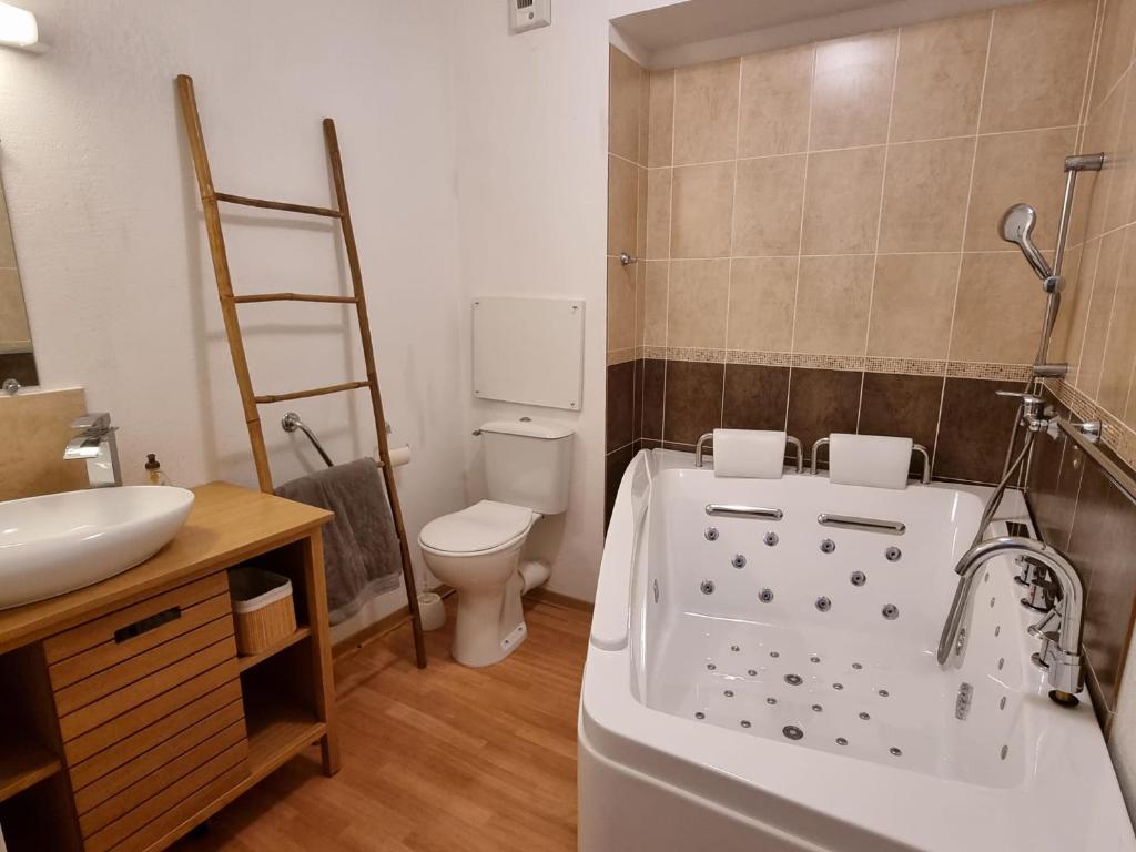 une salle de bain avec une baignoire, des toilettes et un lavabo dans l'établissement LES ORRES 1800 Appartement 4 p JACUZZI balnéo privé Vue piste piscine résidence, aux Orres
