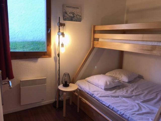 - une chambre avec des lits superposés et une table avec une lampe dans l'établissement Montchavin Les Côtes vue Mont-Blanc, à La Plagne Tarentaise