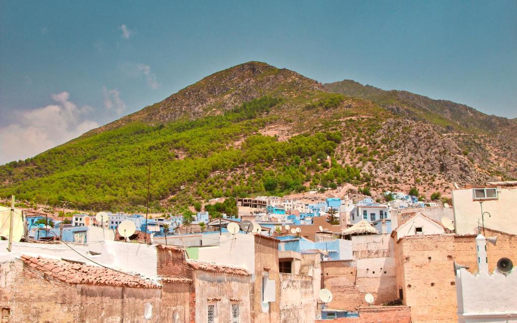 une vue d'une ville avec une montagne en arrière-plan dans l'établissement RIAD LA SANTA, à Chefchaouen