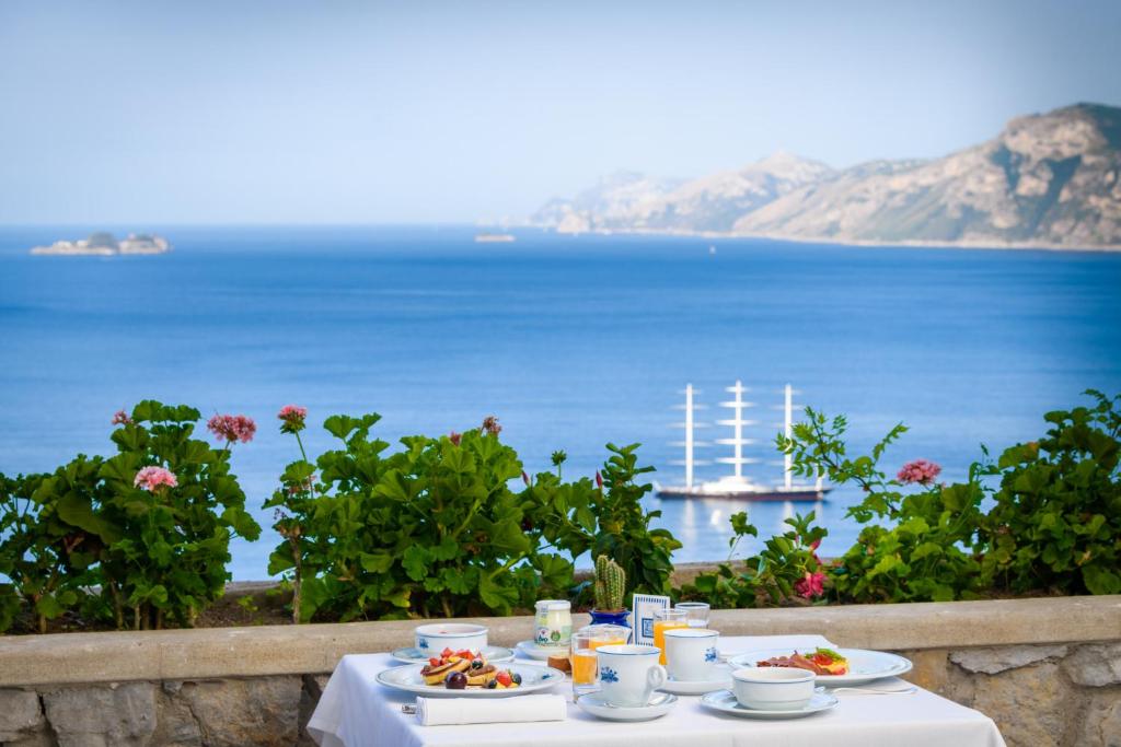 - une table avec de la nourriture et une vue sur l'océan dans l'établissement Grand Hotel Tritone, à Praiano