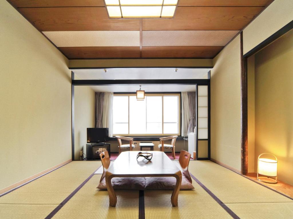 un salon avec une table et des chaises dans l'établissement jyozankei Shikanoyu, à Jozankei
