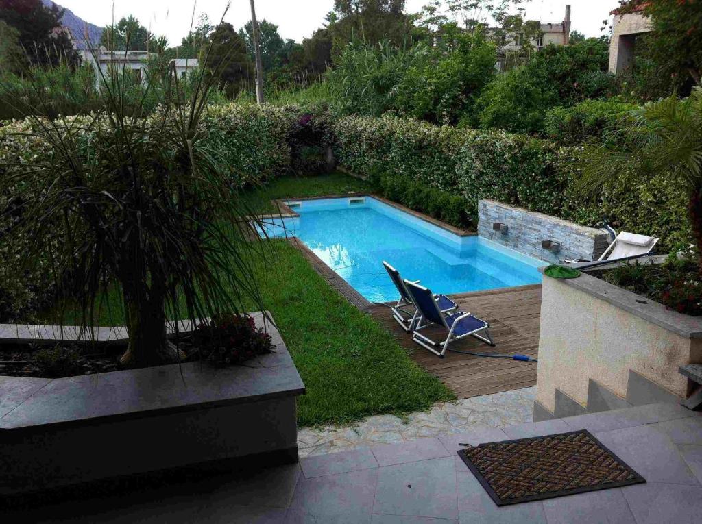- une piscine avec une chaise dans la cour dans l'établissement Villa Le Lanterne Pool & Relax, à Mondello