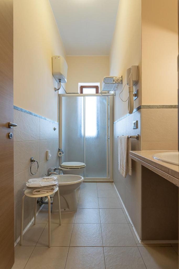 une salle de bain avec une douche, des toilettes et un lavabo dans l'établissement Club Azzurro Hotel & Resort, à Porto Cesareo