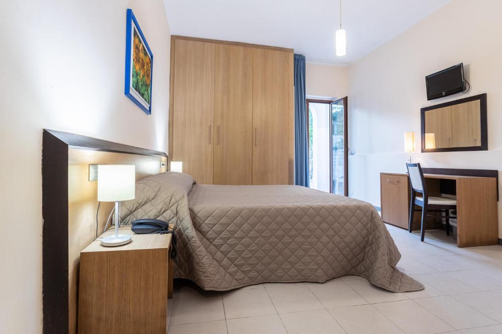 une chambre d'hôtel avec un lit et un bureau avec un bureau dans l'établissement Club Azzurro Hotel & Resort, à Porto Cesareo 151 autres photos