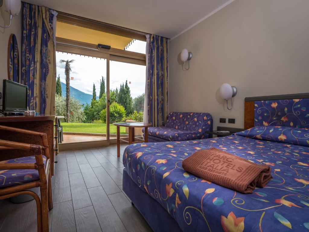 une chambre avec un lit, une chaise et une fenêtre dans l'établissement Hotel Leonardo Da Vinci, à Limone sul Garda