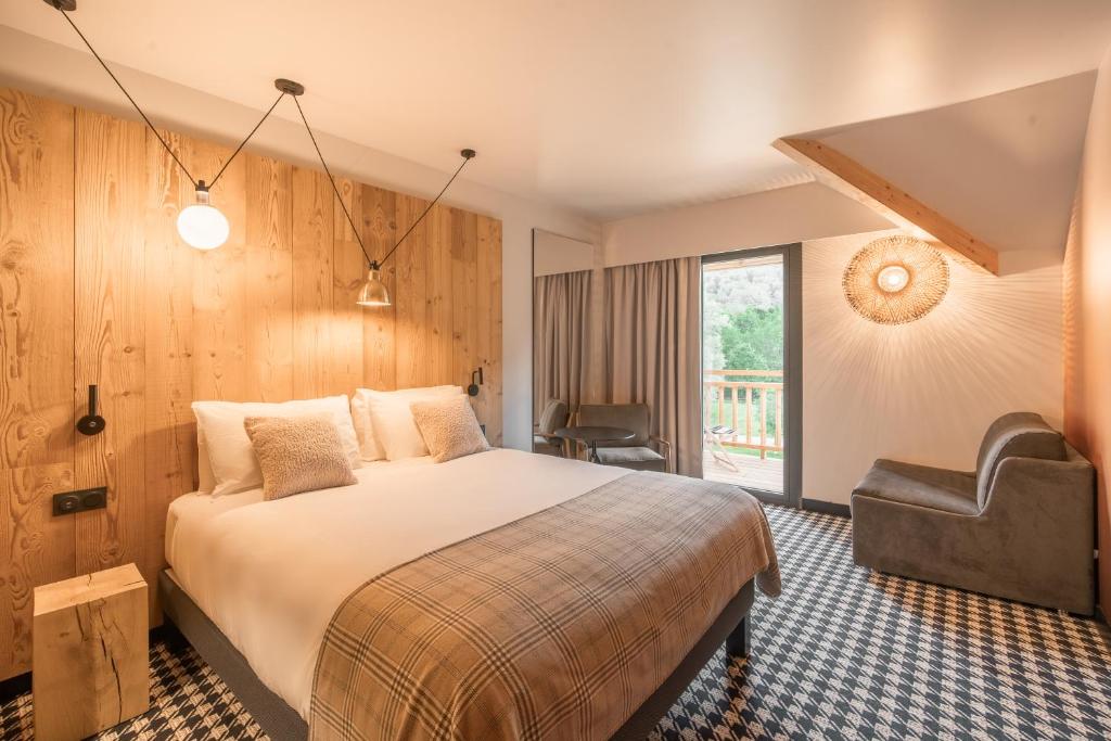 une chambre d'hôtel avec un lit et une chaise dans l'établissement Mercure Peyragudes Loudenvielle Pyrénées, à Loudenvielle