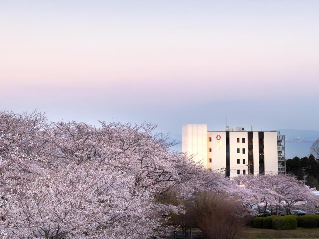 un bâtiment avec des pinkakura devant un bâtiment dans l'établissement Akarinoyado Togetsu, à Beppu