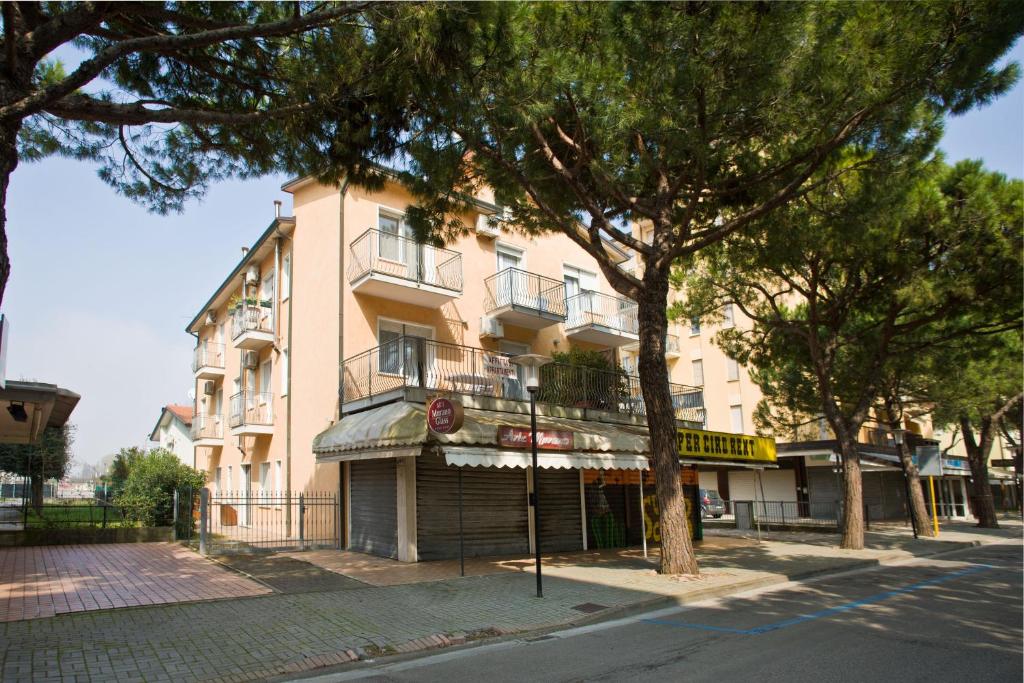 un bâtiment situé dans une rue avec des arbres devant elle dans l'établissement Villa Hanna, à Lido di Jesolo